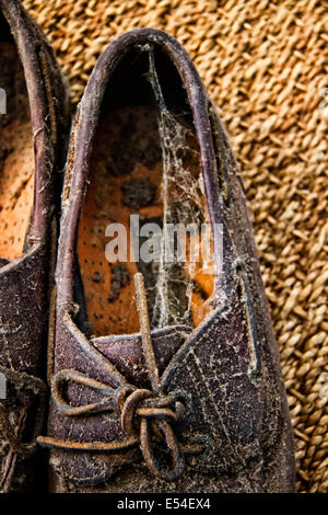 Koppeln von alten Lederschuhe in Staub und Spinnweben bedeckt Stockfoto