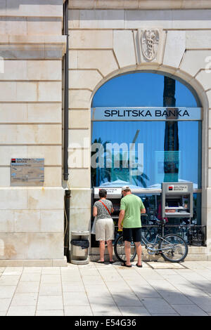 Koppeln Sie stehen durch einen Geldautomaten außerhalb ein Zweig der Splitska Banka (im Besitz von Société Générale) im Stadtzentrum von Split Stockfoto