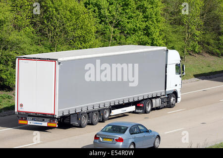 Eine unmarkierte Sattelschlepper und ein Auto fährt auf der Autobahn M20 in Kent, England Stockfoto