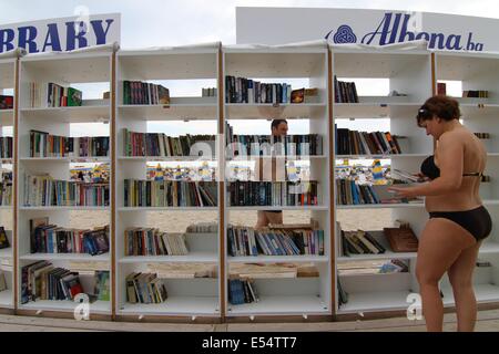 Varna, BGR. 20. Juli 2014. Menschen suchen und lesen Sie Bücher in den ersten jemals frei Strandbibliothek in Bulgarien am Schwarzen Meer Resort von Albena, Sonntag, 20. Juli 2014 eröffnet. In Albena eröffnet die erste Beach-Bibliothek in der Europäischen Union und der dritte weltweit und in den Regalen sind angeordnet über 2500 Bände in mehr als 10 Sprachen. Die Bibliothek ist völlig kostenlos. Die Titel sind sorgfältig ausgewählt, für jeden Geschmack - Weltklassiker, Krimis, Mysterien, romantische Lesungen, Memoiren. Die Touristen nehmen ein Buch kostenlos ohne einen Bibliotheksausweis. Wenn sie das Buch nicht gelesen haben, die sie getroffen haben, Stockfoto