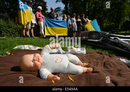 Mehrere Dutzende von Menschen kamen vor der russischen Botschaft in Prag, Tschechische Republik, am Sonntag, 20. Juli 2014, um auf Russlands Rolle bei dem Absturz einer malaysischen Ebene im Osten der Ukraine, deren Abschuss zeigen sie die Schuld auf Russland. Ein dunkles Tuch, das sie auf dem Boden verteilt, Schutt, persönliche Gegenstände von Personen und ein Kind-Dummy Handauflegen vertreten den Ort der Tragödie. (CTK Foto/Katerina Sulova) Stockfoto