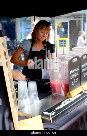 weibliche Stall Inhaber mischen Frucht-Smoothies und Säfte bei Southsea Food fair Festival 2014 England uk Stockfoto