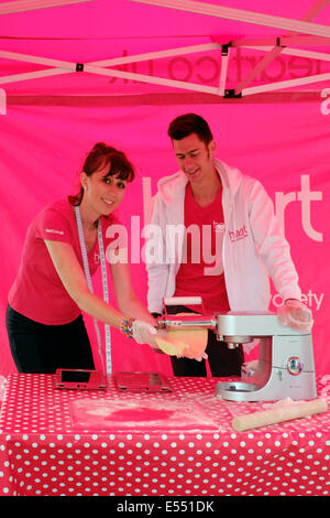 Mitarbeiter am Herzen Radio Stand zeigt Gebäck machen bei Southsea Food fair Festival 2014 England uk Stockfoto