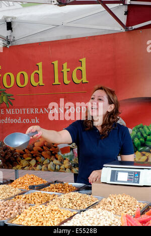 weibliche Standinhaber Ausschank Snacks versuchen, auf das Southsea Essen fair Festival 2014 England uk Stockfoto