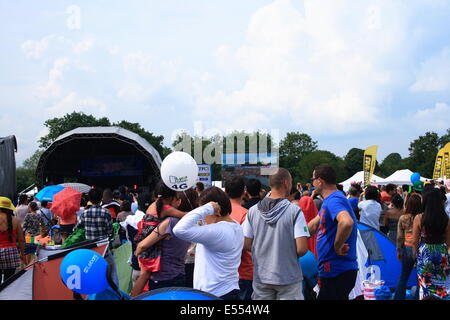 Walton, Surrey, UK. 20. Juli 2014. Menschen sammeln und zwischen Bühne Handlungen in der Backgound mit Familie und Freunden zu chatten. Bildnachweis: Paul Hamilton/Alamy Live-Nachrichten Stockfoto