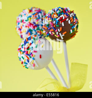 Drei Kuchen Pops vor einem gelben Hintergrund Stockfoto