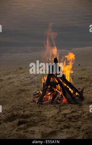 Lagerfeuer am sandigen Strand nach Sonnenuntergang Stockfoto