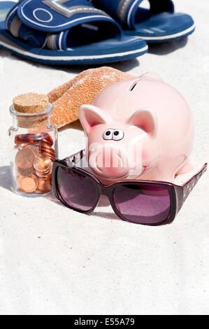 Sparschwein und Strand-Accessoires, sparen für den Urlaub Stockfoto