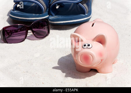 Sparschwein und Strand-Accessoires, sparen für den Urlaub Stockfoto