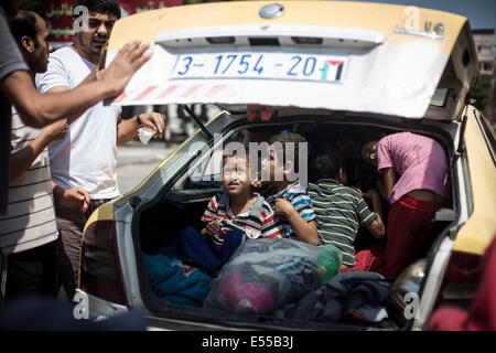 Gaza. 21. Juli 2014. Eine palästinensische Familie bereitet vom Beith Hannoun nach einer UN-Schule im Scheich-Said fliegen wurden Hunderte von Menschen nehmen Zuflucht vor den Bombardierungen. Palästinenser fliehen Stadtteil Beit Hannoun während schweren israelischen Beschuss im Gazastreifen, Palästinensische Gebiete. Bildnachweis: Ibrahim Khader/Pacific Press/Alamy Live-Nachrichten Stockfoto