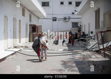 Gaza. 21. Juli 2014. Palästinensischen Familie erwarten fliegen weg von Beith Hannoun zu einer UN-Schule im Scheich-Said wurden Hunderte von Menschen nehmen Zuflucht vor den Bombardierungen. Palästinenser fliehen Stadtteil Beit Hannoun während schweren israelischen Beschuss im Gazastreifen, Palästinensische Gebiete. Bildnachweis: Ibrahim Khader/Pacific Press/Alamy Live-Nachrichten Stockfoto