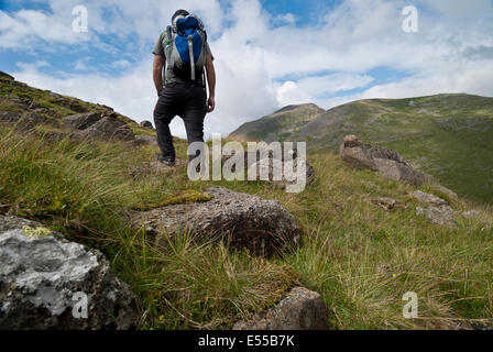 Männliche Wanderer mit Rucksack mit Blick auf großen Giebel von Seathwaite fiel, Lake District, Cumbria Stockfoto