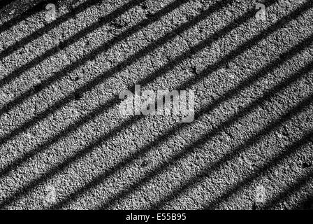 Ein schwarz-weiß Foto von Geländer Schatten auf dem Boden Stockfoto