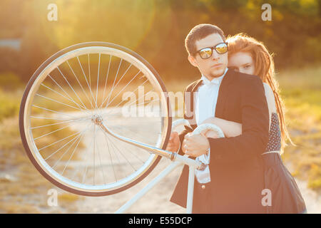 Stilvolle Pärchen - der Mann mit den Mädchen und Fahrrad im freien Stockfoto