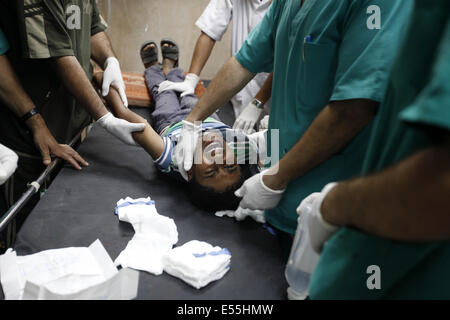 Deir Al-Balah, Gaza-Streifen. 21. Juli 2014. Ein palästinensischer Jugendlicher verletzt durch einen Beschuss von israelischen wird von Ärzten in der Al-Aqsa-Krankenhaus im Notfall behandelt. ICRC koordiniert mit dem israelischen Militär einen humanitäre Besuch im belagerten Krankenhaus ermöglicht die Evakuierung der letzten Patienten. Wurden fünf Palästinenser getötet und 30 verletzt wurden bei diesem Angriff. Bildnachweis: ZUMA Press, Inc./Alamy Live-Nachrichten Stockfoto