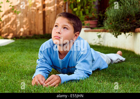 9-10 Jahre alten Jugendlichen Menschen Japanisch/Kaukasischen jungen Festlegung auf Gras denken durchdachte Träumen sitzen im Hinterhof zu reflektieren. Herr © Myrleen Pearson Stockfoto