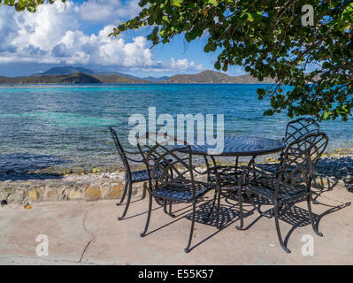 Zwei leere Stühle am Strand am Rand des Wassers von Coral Bay auf der Karibik Insel St. John in den US Virgin Islands Stockfoto