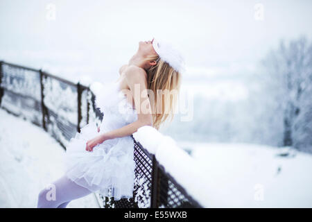 Ballerina, stützte sich auf den Zaun im Schnee Stockfoto