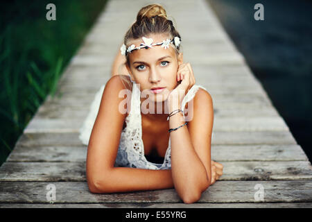 Junge Frau im weißen Kleid auf einem Steg Stockfoto