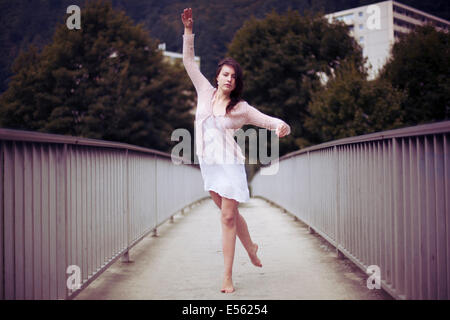 Junge Frau tanzen barfuß auf einer Brücke Stockfoto