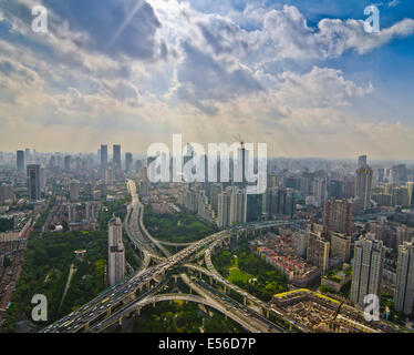 Panoramablick auf den Nachmittagsverkehr während der Hauptverkehrszeit auf dem Yanan-Expressweg, der sich an einem ungewöhnlich klaren, flauschigen wolkenlosen Tag an der Skyline von Westschanghai kreuzt. Stockfoto