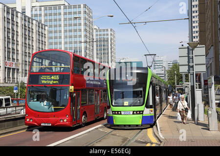 Eine Straßenbahn auf Croydon Tramlink-System hält auf Wellesley Road in Croydon Stadtzentrum entfernt. Ein London-Bus fährt. Stockfoto