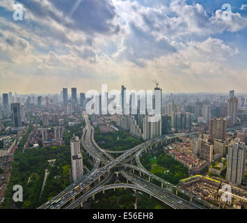 Panoramablick auf den Nachmittagsverkehr während der Hauptverkehrszeit auf dem Yanan-Expressweg, der sich an einem ungewöhnlich klaren, flauschigen wolkenlosen Tag an der Skyline von Westschanghai kreuzt. Stockfoto