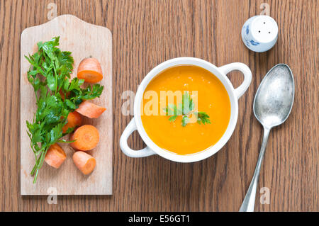 Karottensuppe mit frischen Karotten, Petersilie, Löffel und Salzstreuer hautnah Stockfoto