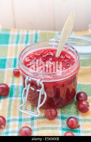 Stachelbeere Konfitüre mit einem Löffel in ein Glas Stockfoto