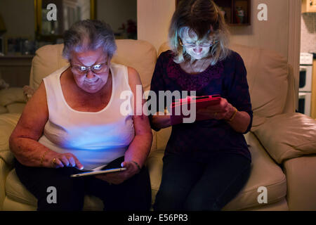 Zwei lady's in vertieft es Tabletten Stockfoto