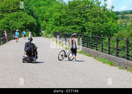 Weibliche Radfahrer, männlich in einem elektrischen Rollstuhl und Wanderer auf Grabstein Viadukt, Monsal Trail, Derbyshire, Peak District National Park, England, Großbritannien Stockfoto