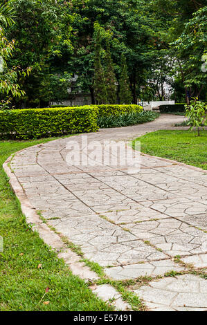 Konkrete Gehweg im Park auf dem grünen Rasen Stockfoto