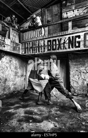27. Juli 2013 Kinder - Kampala, Uganda - Boxen an der Rhino Boxing Club. Katanga in Kampala ist eine Slum-Community, wo mehr als 20.000 Menschen unter Bedingungen extremer Armut und ohne grundlegende Infrastruktur wie permanente Frischwasserversorgung und Backsteinhäuser, inmitten der Shanty-Häuser Leben, eine Gruppe von ambitionierten Kämpfer versuchen, für ein besseres Leben zu erreichen. Während sammeln Bananenschalen um zu überleben, sie sind begeistert von den Boxen, und sie weiterhin ihren Kampf trotz der Verachtung, die oft offen geäußert wird. Rhino-Boxer-Club mitten in den Slums von Katanga, so dass fo Stockfoto