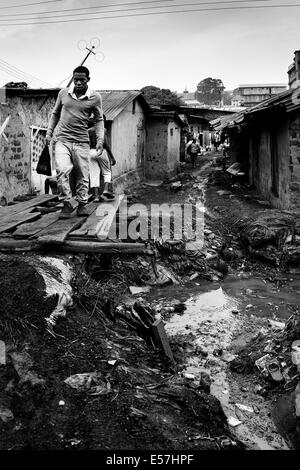 28. Juli 2013 - Kampala, Uganda - A Hauptstrom, relativ stagnierend verläuft in der Mitte dieser Gemeinschaft und wird als eine Wasserquelle für waschen, Kochen und oft als Toilette. Keine dauerhafte Süßwasser ist verfügbar. Katanga in Kampala ist eine Slum-Community, wo mehr als 20.000 Menschen unter Bedingungen extremer Armut und ohne grundlegende Infrastruktur wie permanente Frischwasserversorgung und Backsteinhäuser, inmitten der Shanty-Häuser Leben, eine Gruppe von ambitionierten Kämpfer versuchen, für ein besseres Leben zu erreichen. Während sammeln Bananenschalen um zu überleben, sind sie leidenschaftlich über Boxen und th Stockfoto