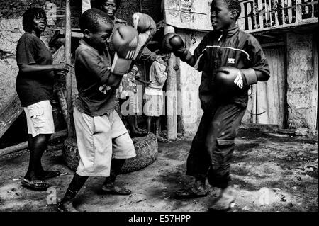 27. Juli 2013 - betreut Kampala, Uganda - Kids Boxen an der Rhino Boxing Club von Helene und Diana. Katanga in Kampala ist eine Slum-Community, wo mehr als 20.000 Menschen unter Bedingungen extremer Armut und ohne grundlegende Infrastruktur wie permanente Frischwasserversorgung und Backsteinhäuser, inmitten der Shanty-Häuser Leben, eine Gruppe von ambitionierten Kämpfer versuchen, für ein besseres Leben zu erreichen. Während sammeln Bananenschalen um zu überleben, sie sind begeistert von den Boxen, und sie weiterhin ihren Kampf trotz der Verachtung, die oft offen geäußert wird. Der Rhino-Boxer-Club mitten in t Stockfoto