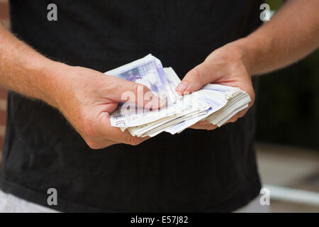 Übergabe de Geldscheine. Zählen vielleicht über Geld in bar bezahlen. Geld ist UK cash Sterling. Stockfoto