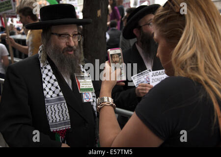 Große pro-palästinensische, anti-israelische Kundgebung in der Nähe des israelischen Konsulats in New York City. Dann marschierte die Gruppe durch Midtown Manhattan. Eine Frau fotografiert auf dem marsch einen pro-palästinensischen orthodoxen Juden. Stockfoto