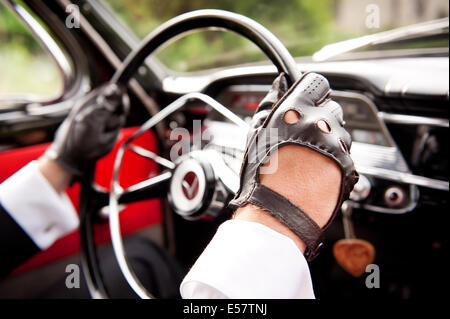 Lederhandschuhe auf Treiber Hände am Lenkrad Volvo 544 Stockfoto