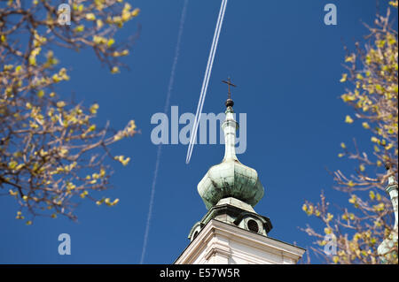 Flugzeug-Kondensstreifen und Kreuz am Turm Stockfoto