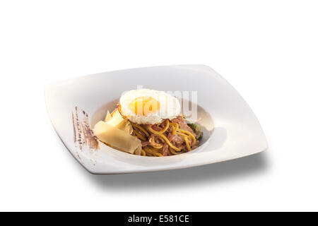 Spaghetti mit frischem grünem Spargel und Speck, dekoriert mit Spiegelei isoliert auf weißem Hintergrund Stockfoto