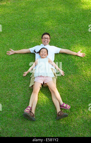 Vater und Tochter zusammen auf einer Wiese liegend Stockfoto