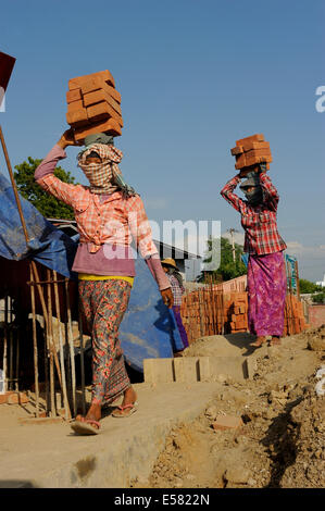 Weibliche Bauarbeiter tragen Ziegel auf ihren Köpfen, Hochhaus, Baustelle, Mandalay, Myanmar Stockfoto