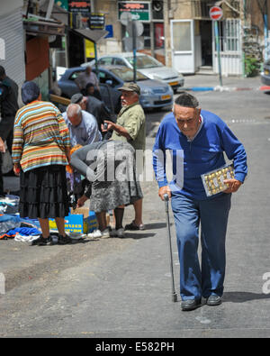 Ein Alter Mann mit einer Schachtel Pralinen geht in Richtung Machane Yehuda-Markt, Jerusalem, Israel Stockfoto