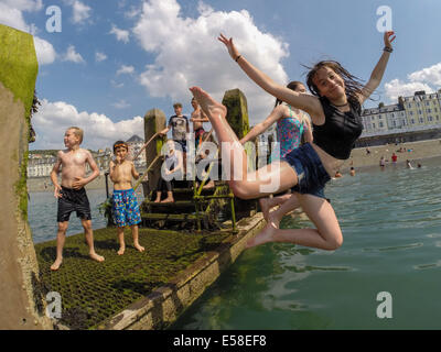 Aberystwyth, Wales, UK. 23. Juli 2014.  Da Temperaturen zu einer Spitze in der hohen 20er Jahre Celsius klettern, finden Gruppen von Kindern im Sommerurlaub einen Weg der cooling-off bei heißem Wetter durch einen Sprung ins Meer bei Aberystwyth an der Westküste Wales UK.  Die Hitzewelle wird voraussichtlich ein weiteres paar Tage dauern, mit Projekt Temperaturen fast bis 30c in etwa landeinwärts Orte Photo Credit: Keith Morris/Alamy Live-Nachrichten Stockfoto