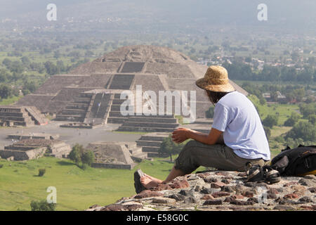 Ein Tourist auf der Pyramide der Sonne blickt auf die Pyramide des Mondes in der Ferne, Teotihuacan, Mexiko. Stockfoto