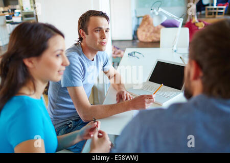 Junger Mann seinem Geschäftspartner bei Treffen im Büro anhören Stockfoto