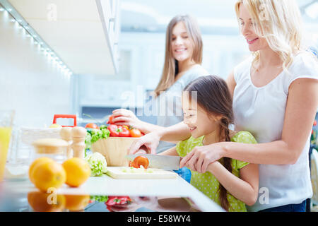 Porträt von glückliche Mutter und zwei Töchtern in der Küche Stockfoto