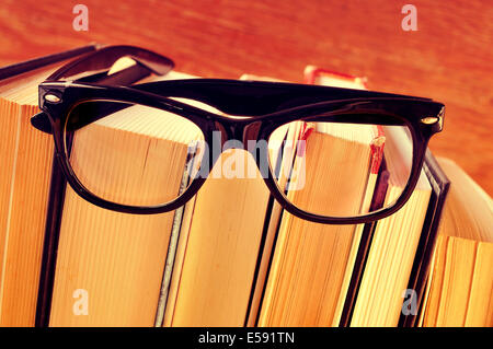 eine Brille auf einen Stapel Bücher, mit einem Retro-Effekt Stockfoto