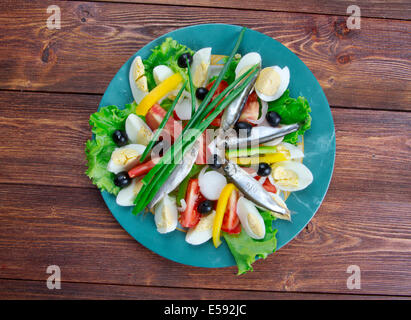 Nicoise Salat mit Sardellen komponierte Salat aus Tomaten, Thunfisch, hartgekochten Eiern, Niçoise Oliven und Sardellen, bekleidet mit einem Stockfoto