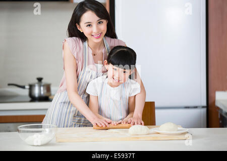 Glückliche Mutter und Tochter Teig ausrollen Stockfoto